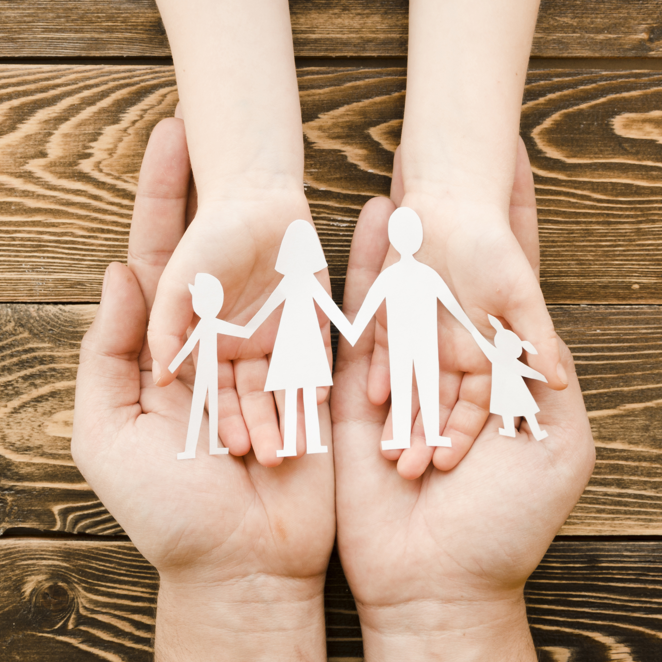 Hands holding paper family cutout