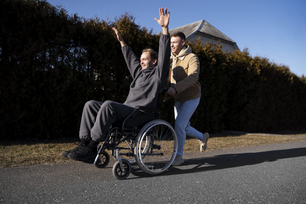 Man in wheelchair celebrating outdoors